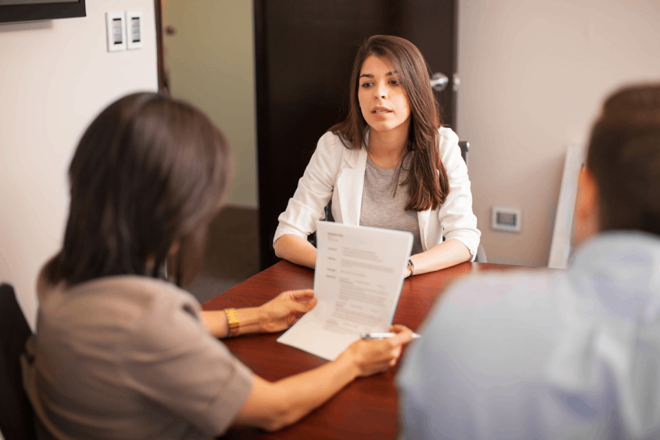 Ejecutiva habla con una pareja en una oficina